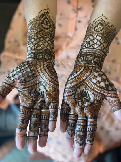 A lovely Karwachauth design with lotus motifs and detailed patterns extending up the wrists.