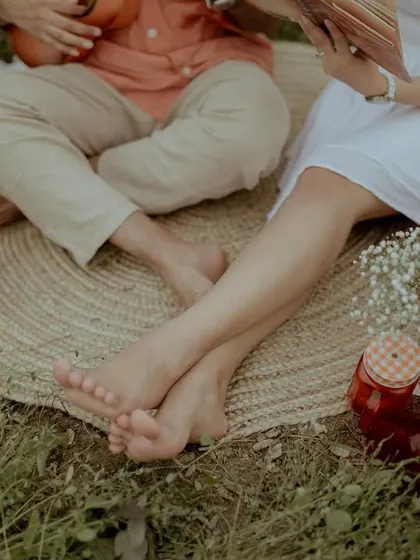A close-up on the couple's bare feet, emphasizing the relaxed and grounded nature of the shoot.