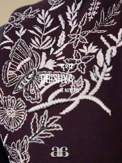 The soul of our work is in the details. This close up view showcases the exquisite silver hand embroidery, featuring a butterfly motif, that adorns our space blue bundi set, reflecting our commitment to meticulous craftsmanship.
