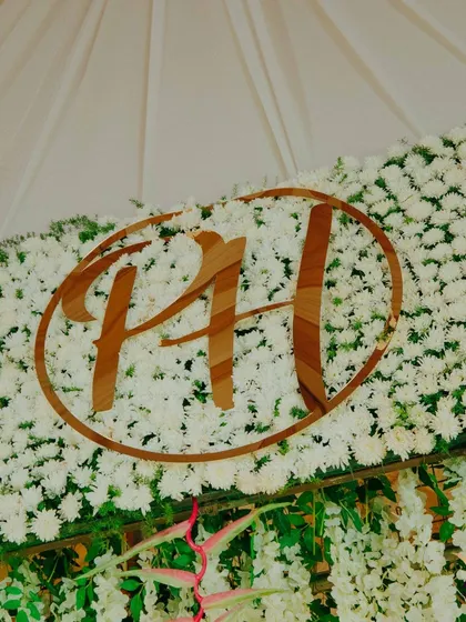 A custom monogram of the couple's initials set against a wall of fresh white flowers. This is a wonderful way to personalize the wedding decor.