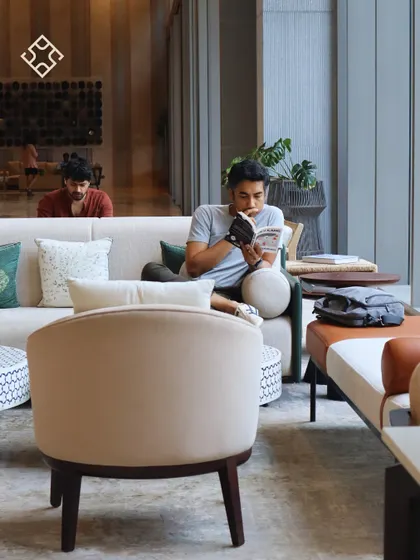 Two customers working and reading in our comfortable sofa area, a perfect example of how our space accommodates both work and relaxation.