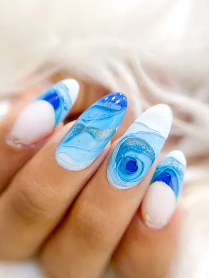 A close-up of the blue mosaic nails, showing the depth and the subtle shimmer within the layers of color.