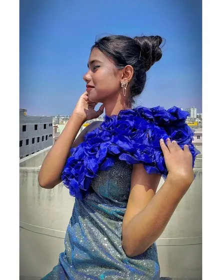 A close-up of the unique handcrafted floral shoulder detail on this modern gown.