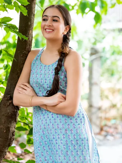 A happy, relaxed portrait taken outdoors by a tree. The natural light and green surroundings create a fresh and authentic feel.