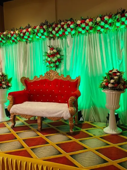 This stage setup shows how colored lighting can completely change the mood. Here, green uplighting gives a modern twist to a traditional floral backdrop and red sofa.