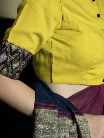 Sunshine stitched into style. Our yellow cotton boat neck blouse with a front button detail and contrasting printed sleeve cuffs is a simple yet elegant choice for the season.
