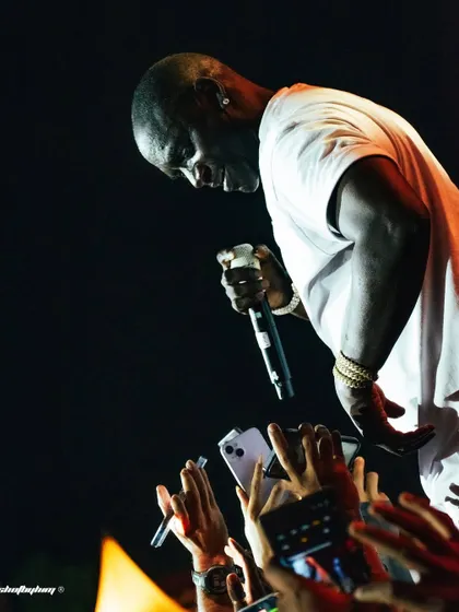 Akon connects with his fans in Bangalore, leaning over the stage as a sea of phones captures the moment. This image highlights the intimate bond between a global superstar and his audience.