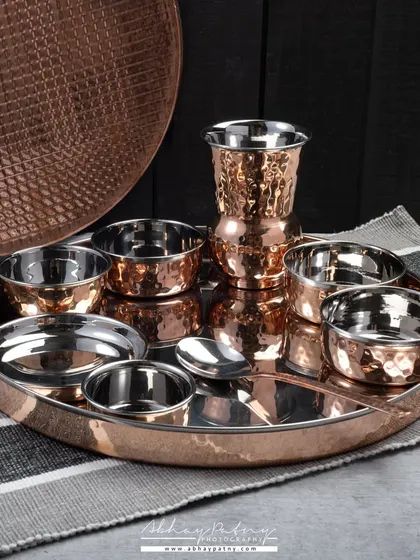 A complete copper and steel thali set, beautifully arranged to show all the components. This kind of group shot is essential for selling product sets and combos.