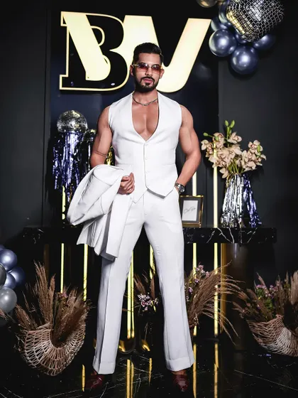 This powerful stance showcases the clean lines and sharp tailoring of our all-white bespoke suit. It's a look designed for making an unforgettable entrance.