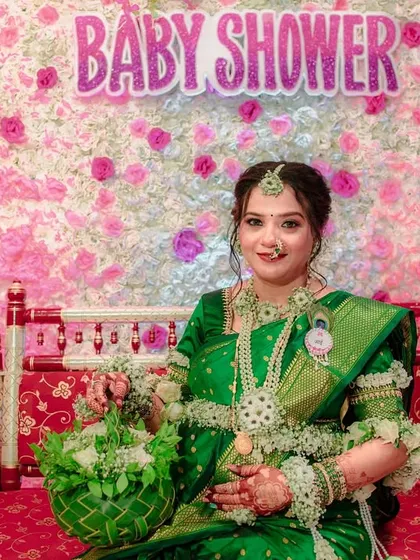 The complete look for a baby shower, with the mom-to-be seated on a decorated swing. She is wearing my custom green and white floral jewellery and holding a matching green floral basket.