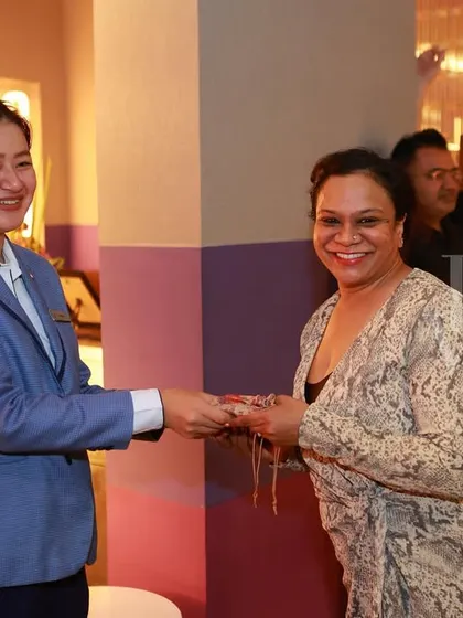 Another happy attendee receiving a gift at our Women's Day party. We love collaborating with partners to make our events special.