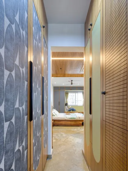 The walk-in wardrobe area features custom doors with varied textures and patterns, adding a layer of detailed craftsmanship to the space.