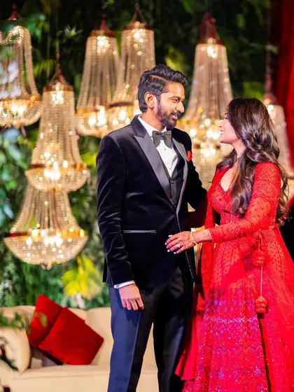 A beautiful couple enjoying their glamorous red-themed reception. The backdrop of crystal chandeliers and lush red florals created a luxurious and romantic setting for their celebration.