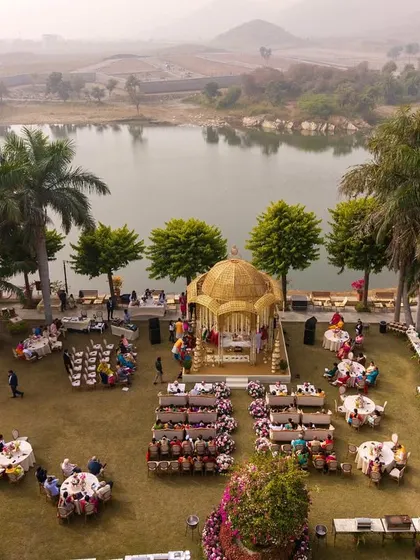 A clearer aerial shot of the beautiful lakeside mandap setup, showing the guest seating and the serene ambiance of the venue.