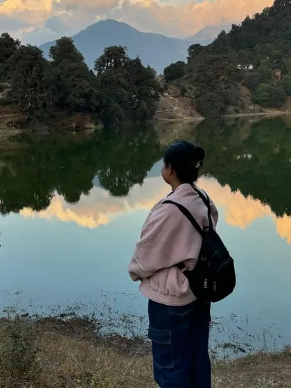 A moment of peace by the stunning Deoriatal lake, with the reflection of the mountains in the clear water.