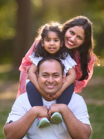 A perfect family portrait filled with smiles. I love the classic "child on shoulders" pose, which creates a beautiful, layered composition and showcases the happy connection between parents and their child.