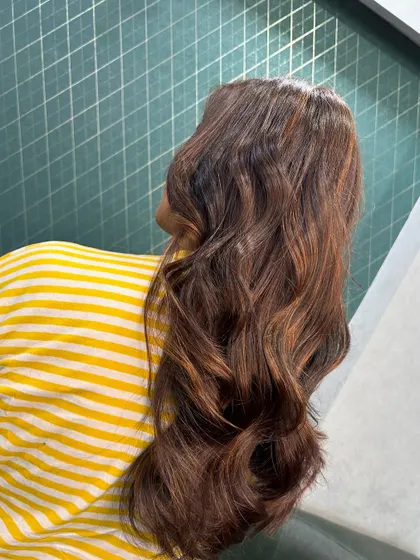 A side angle capturing the light on these beautiful brown waves. The color has depth and dimension, perfect for a fresh look.