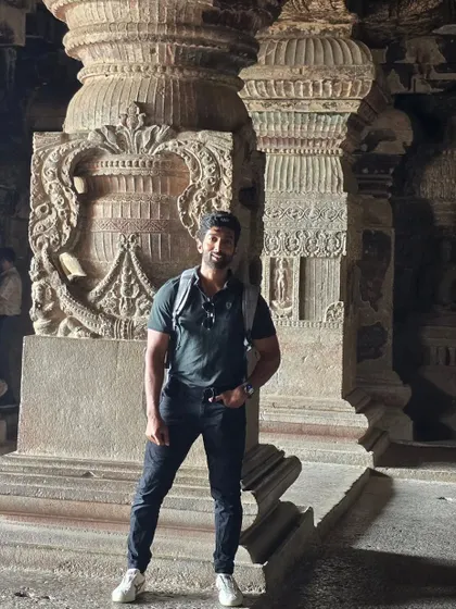 Inside one of the caves, surrounded by massive pillars and intricate carvings that have survived for over a thousand years.