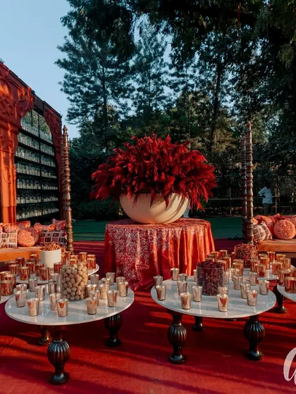 We created a cozy and traditional seating area with a swing against a backdrop of a thousand candles. This space, filled with snacks and surrounded by a massive red floral arrangement, became a central gathering point.