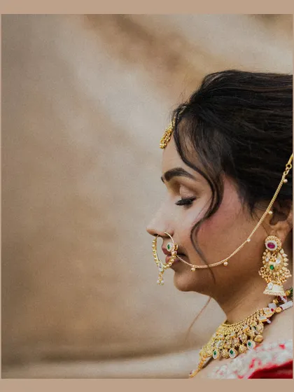 A serene profile shot of the bride, her eyes closed in a moment of quiet contemplation. This close-up beautifully captures the intricate details of her nose ring and jewelry.