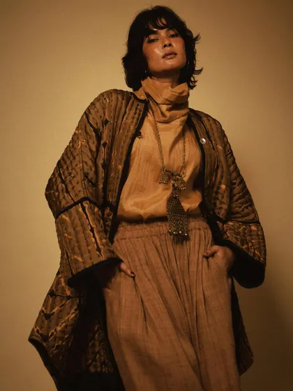 A strong, confident pose in a beautifully crafted quilted jacket. This shot highlights the structure and detail of the garment, showcasing its versatility as a statement piece.