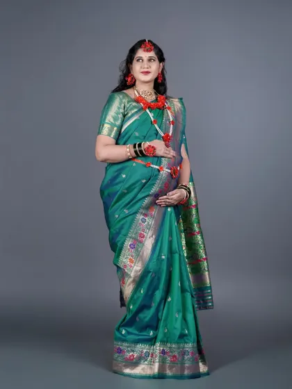 A full-length studio portrait of a mother-to-be dressed in a traditional green Paithani saree and floral jewelry for her Dohale Jevan ceremony. I ensure the rich details of the attire are beautifully captured.