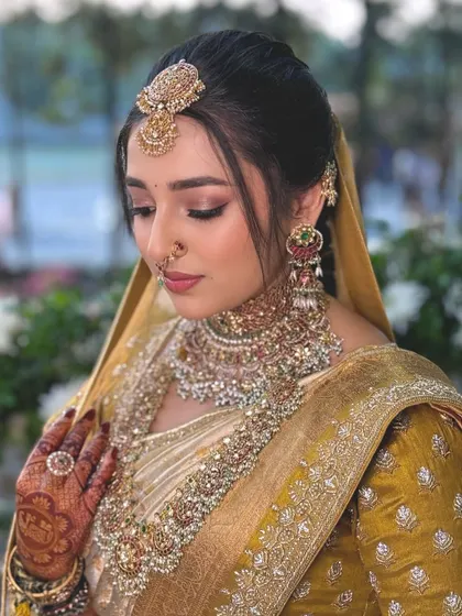 A detailed view of Nischaya's bridal makeup, focusing on the soft smokey eye and the flawless base that defines her features with grace.