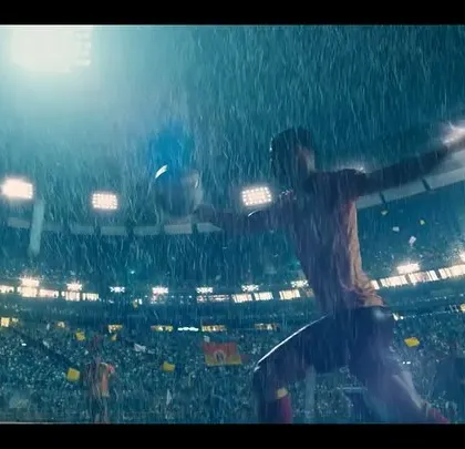 A dramatic, rain-soaked action shot from the East Bengal FC film. The custom-designed jerseys are on full display as the player makes a move.