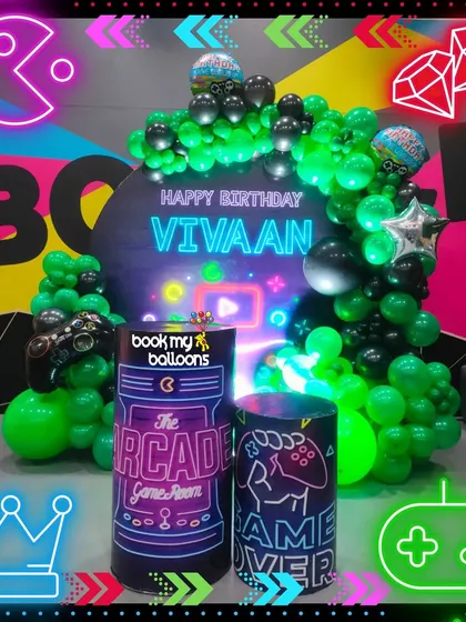 Game on for Vivaan's birthday. This arcade and gamer theme featured neon green and black balloons, a controller-shaped balloon sculpture, and custom "Game Room" pedestals for a high score celebration.