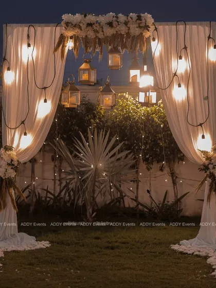 A wider shot of the lantern-lit arch, showcasing how it creates a beautiful frame against the natural greenery. This setup is versatile and can be used for intimate weddings, anniversaries, or elegant garden parties.
