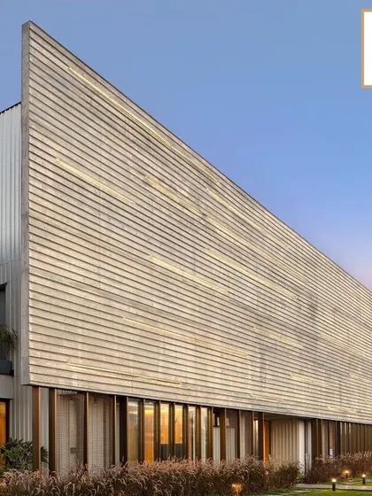 The facade of the award-winning Laxcon Steel Plant Office showcases a textured, brutalist-inspired concrete form. This project is a testament to our philosophy of creating powerful architectural statements for industrial clients that are both functional and visually compelling.