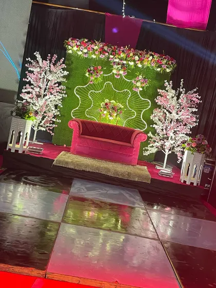 The final stage setup for the pink and black themed 25th-anniversary celebration, complete with cherry blossom trees and a plush pink sofa.