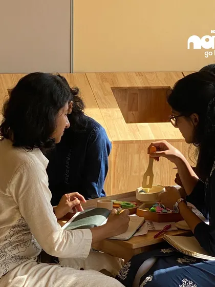 Two women collaborate during a teacher development workshop, deeply engaged in a creative task. I believe in empowering my educators with innovative teaching philosophies to foster a dynamic learning environment.