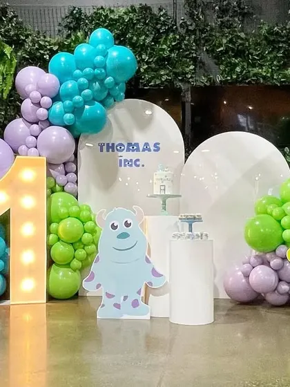 We handle corporate family days and anniversaries with creative, fun themes. This 'Monsters, Inc.' setup for Thomas Inc. included character cutouts, themed balloon colors, and a large light-up number to celebrate their milestone.