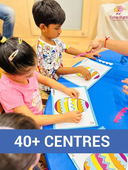 Children are focused on a craft activity, using fine motor skills to place pieces on a colorful egg design. Art and craft sessions are a key part of our curriculum, fostering creativity and dexterity.