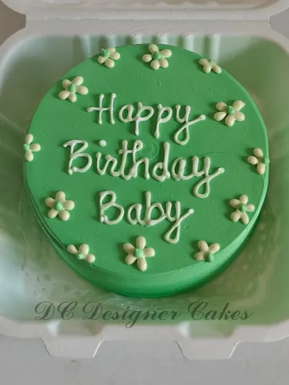 A simple and sweet bento cake for a birthday. This green mini cake is decorated with tiny white flowers and a "Happy Birthday Baby" message, perfect for a small, heartfelt celebration.