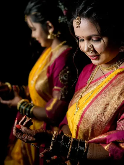 Using reflections to create an artistic portrait, this image shows the bride from multiple angles, highlighting her profile and traditional attire.