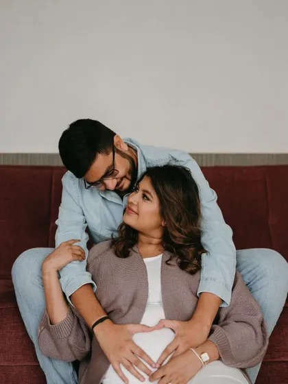 A heartwarming photo celebrating their growing family. Her makeup is soft and glowing, perfect for capturing this precious memory.