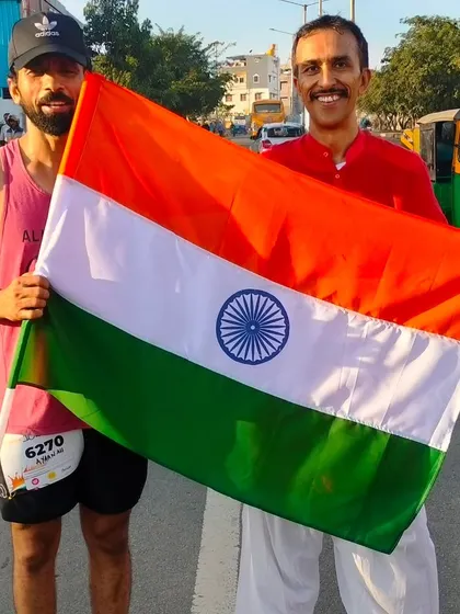 Two runners hold the Indian flag together, a symbol of unity and shared pride at our community event.