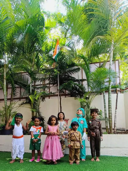 Our little patriots stand proudly by the Indian flag during our Independence Day celebration. Some are dressed as freedom fighters, learning about our nation's history.