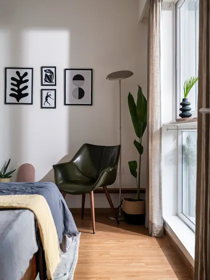 A cozy reading corner in the 'Footloose' bedroom, with a comfortable armchair, modern art prints, and plenty of natural light from the large window.