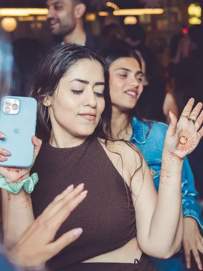 A guest dancing with her phone, capturing the moment while living in it. The December edition of VIBE CHECK was unforgettable.