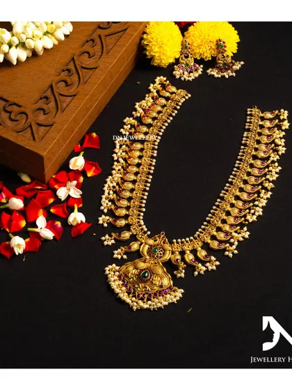 A long mango mala with a peacock pendant. The intricate design and kemp stones make this a classic and beautiful piece.