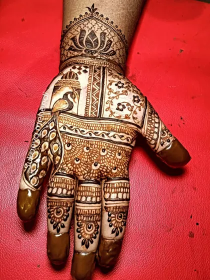 A striking design featuring a peacock within an architectural frame. The fingers are adorned with delicate patterns, and the wrist is finished with a lotus cuff.