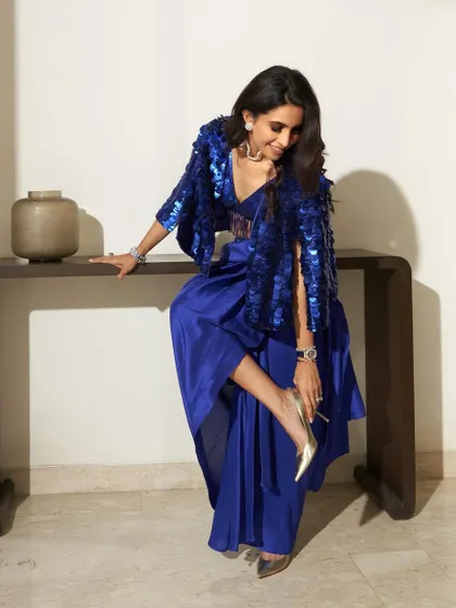 A full-length stylish shot. This shows how the makeup, hair, and outfit come together to create a cohesive and high-fashion look.