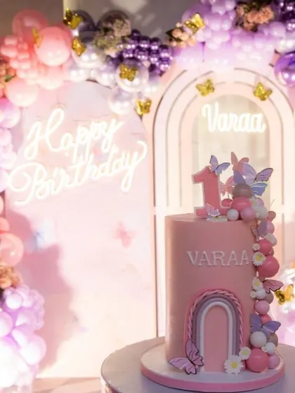 The cake looks so magical next to the "Happy Birthday" neon sign.