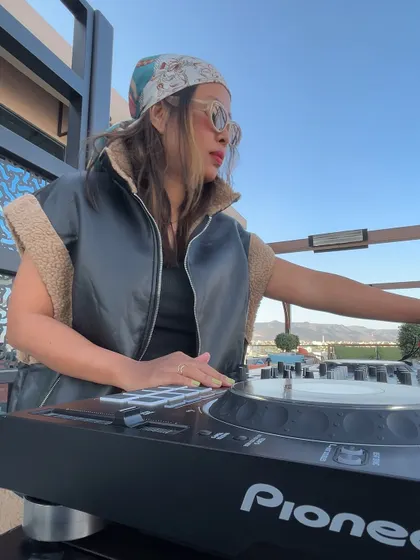 A close-up of me mixing, channeling a vintage glam look. I bring a unique sense of style to every performance.