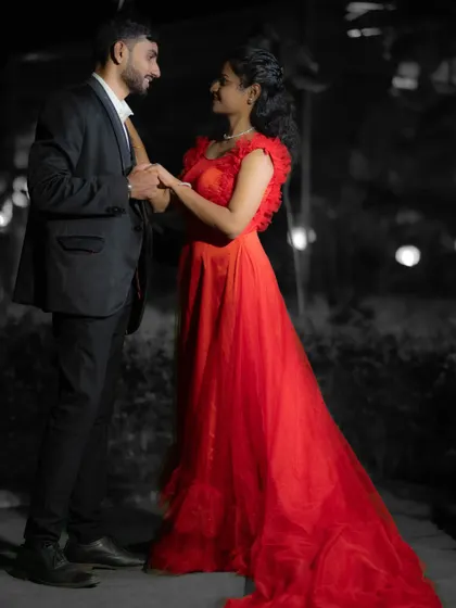 A striking pre-wedding photo using selective color, where the bride-to-be's vibrant red gown stands out against a black and white background.