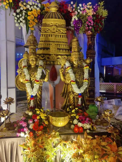 A close-up of the golden deity statues, showing the craftsmanship and the beautiful floral garlands used to adorn them for the wedding ceremony.