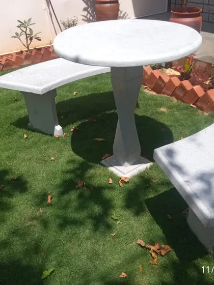 We also provide garden furniture. This stone-finish table and bench set provides a durable and elegant seating area, perfectly integrated into the lawn.